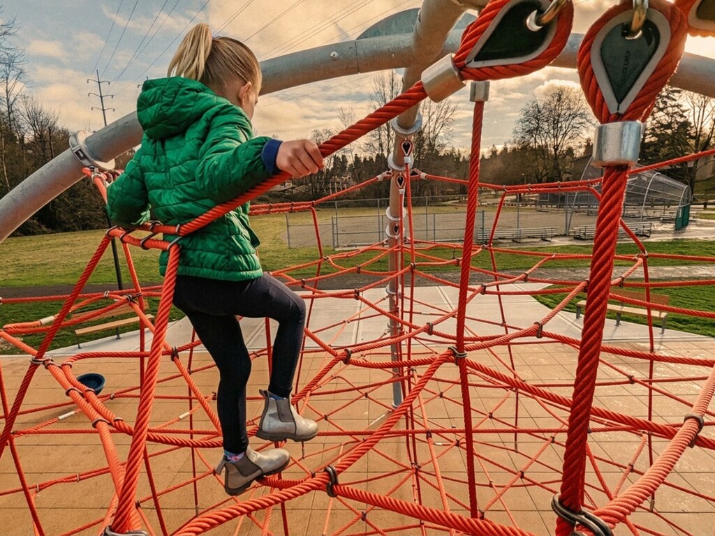 A kid climbing the rope structure at the Skyway Park playground